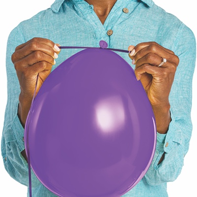 Hands tying ribbon on latex balloon