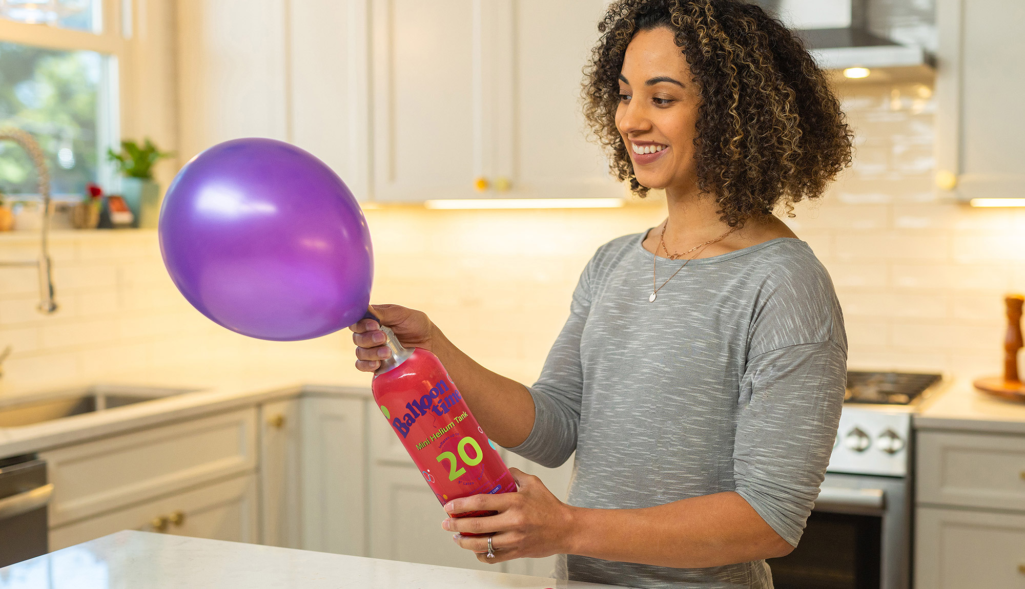 Woman filling balloon with Mini Tank